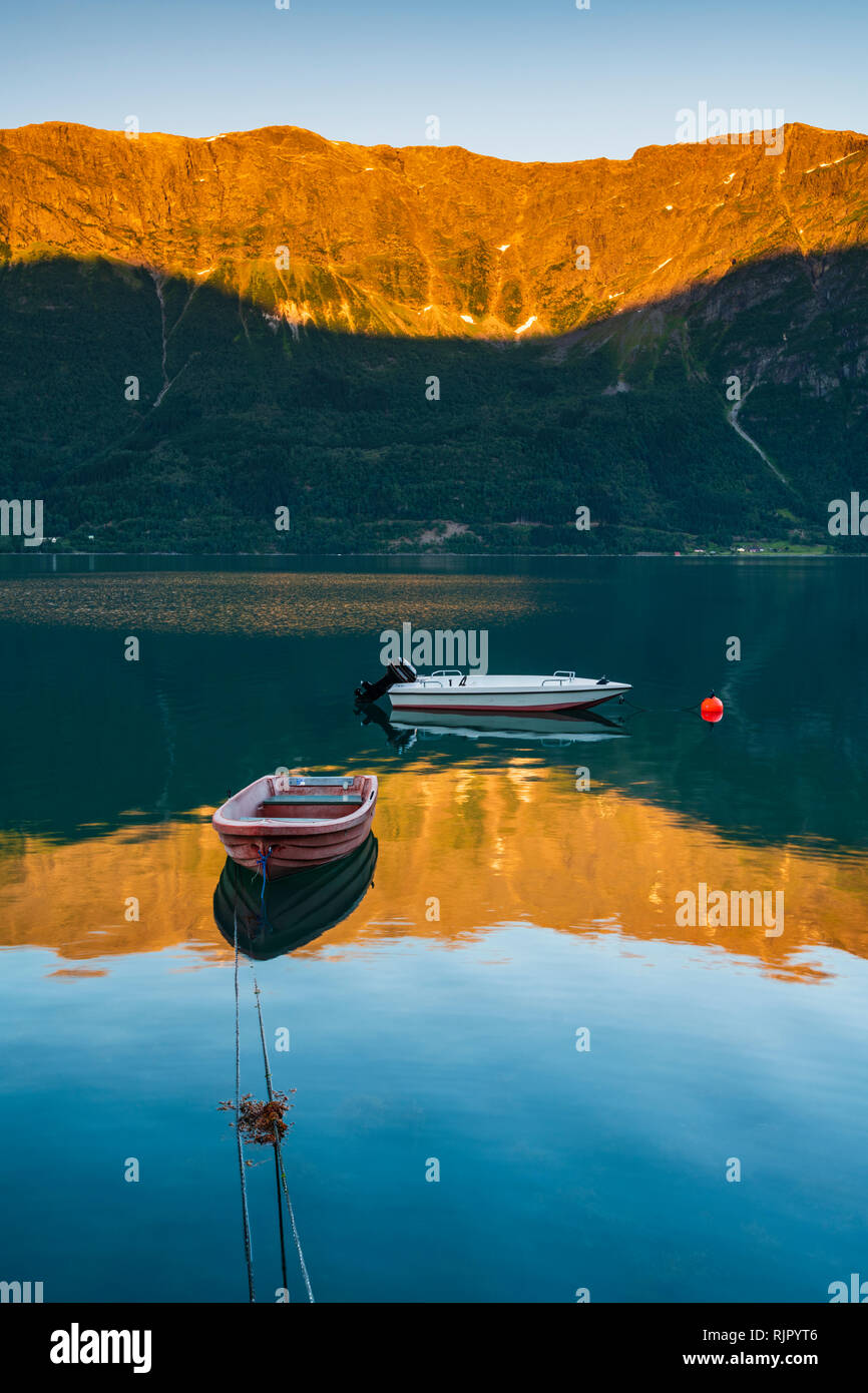 Boats floating on still fjord at sunset, mountains in background, vertical image, Lusterfjord, Norway, Europe Stock Photo