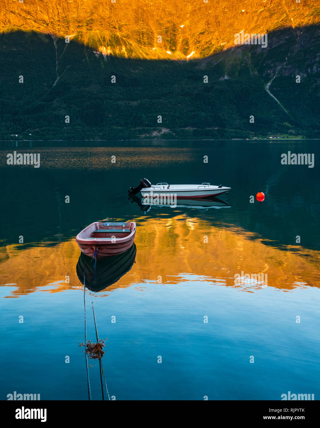 Boats floating on still lake at sunset, Lusterfjord, Norway, Europe Stock Photo