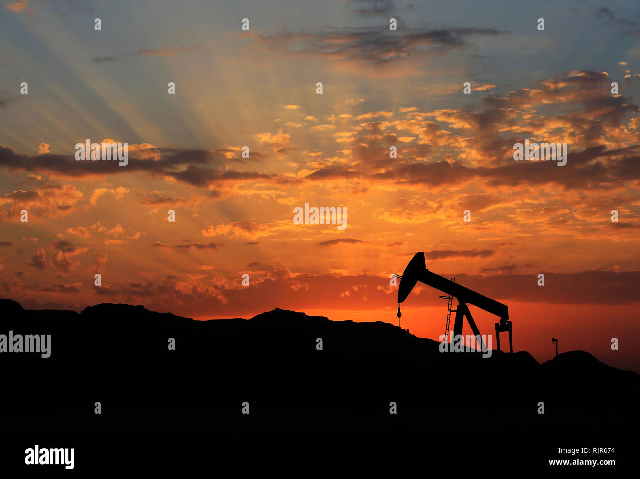 An oil pump is seen at sunset in the desert oil field of Sakhir, Bahrain, on Dec. 13, 2015. (Photo/Hasan Jamali) Stock Photo