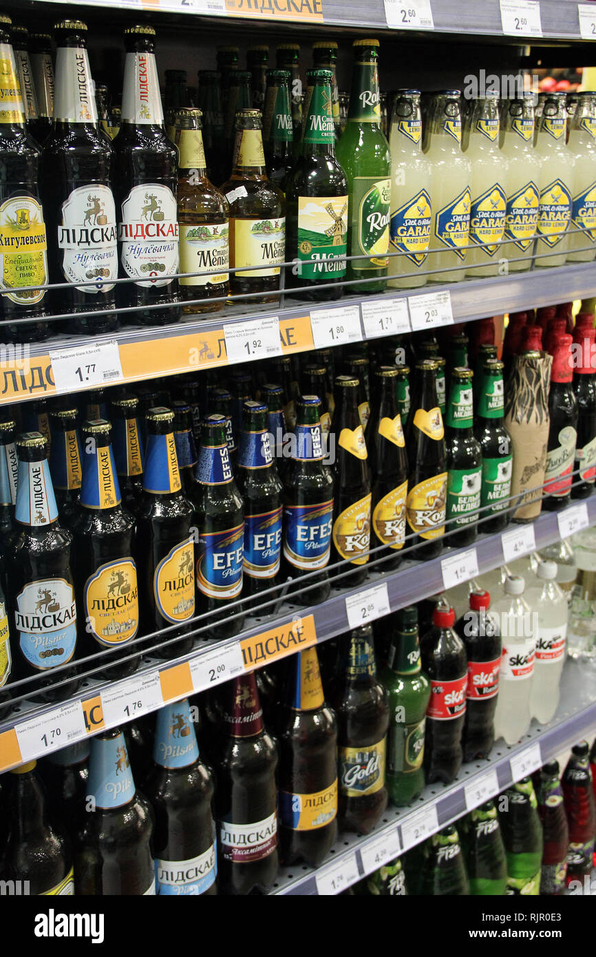 Alcoholic drinks on shelves of supermarket. Alcohol drink market concept. Different kinds of beer on shelves. Domestic and imported beers. Alcoholic b Stock Photo