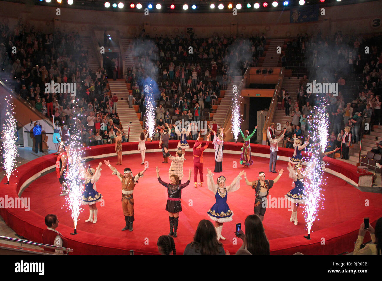 Final performance of all actors with fireworks. Actors in circus arena Stock Photo