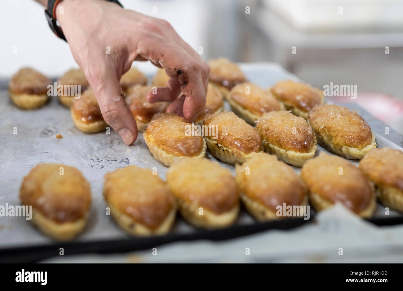 artisan pastry chef placing cake on tray Stock Photo