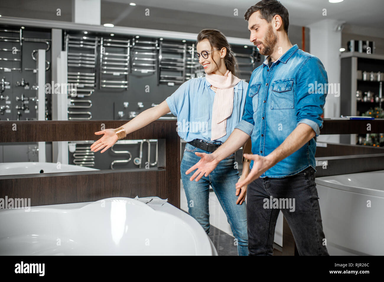 Man and woman choosing new bathtube standing together in the plumbing shop Stock Photo