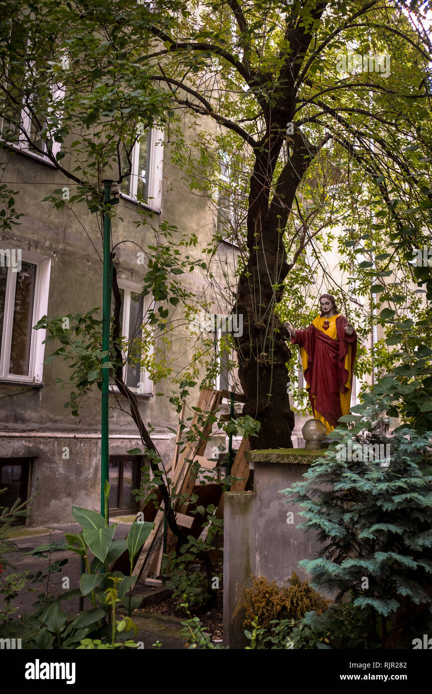 Statue of Jesus in a garden courtyard with tree Stock Photo