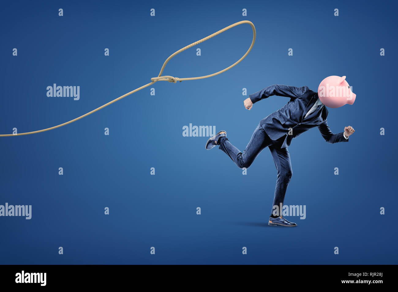 Businessman with a piggy bank head running from a loop on the blue background. Business and finance. Banking and financial industry. Management. Savin Stock Photo