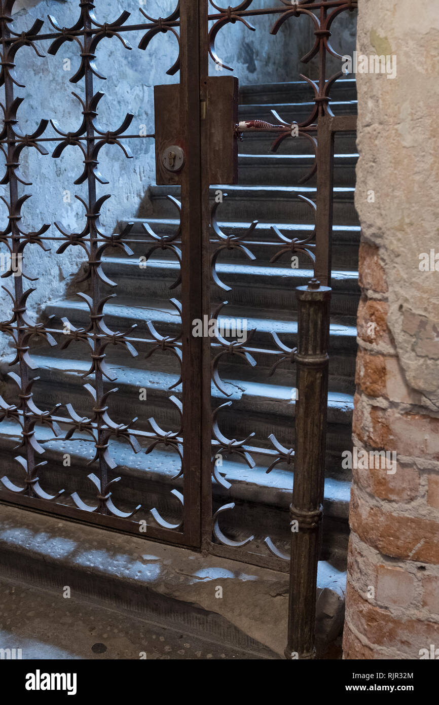 Old locked iron gate with stones steps Stock Photo