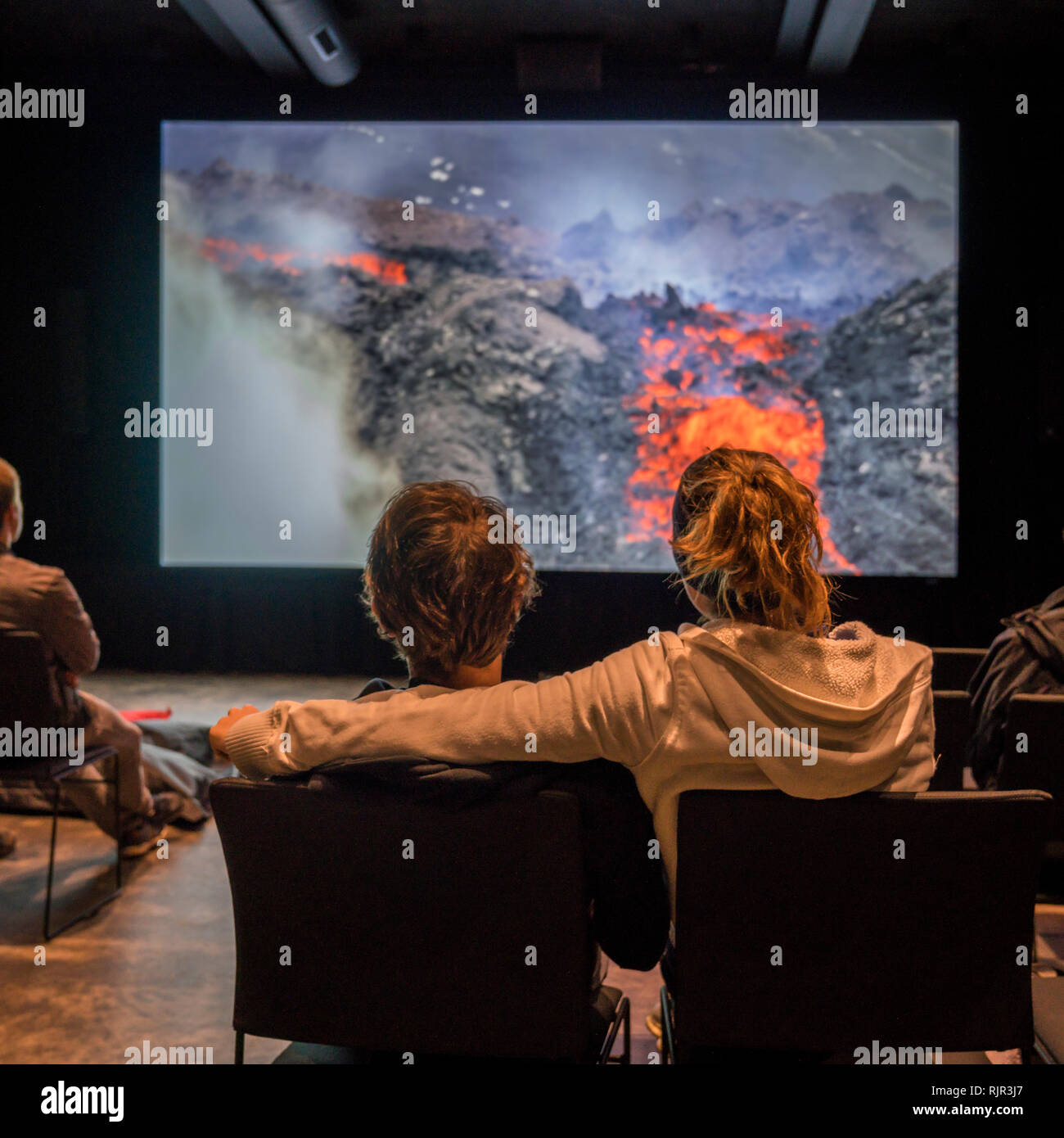 People watching volcanic eruption footage, Lava Centre, Hvolsvollur, Iceland. Stock Photo