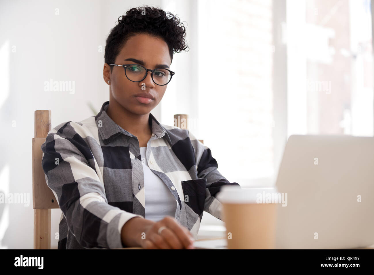 Pensive thoughtful african-american woman thinking of problem solution at work Stock Photo