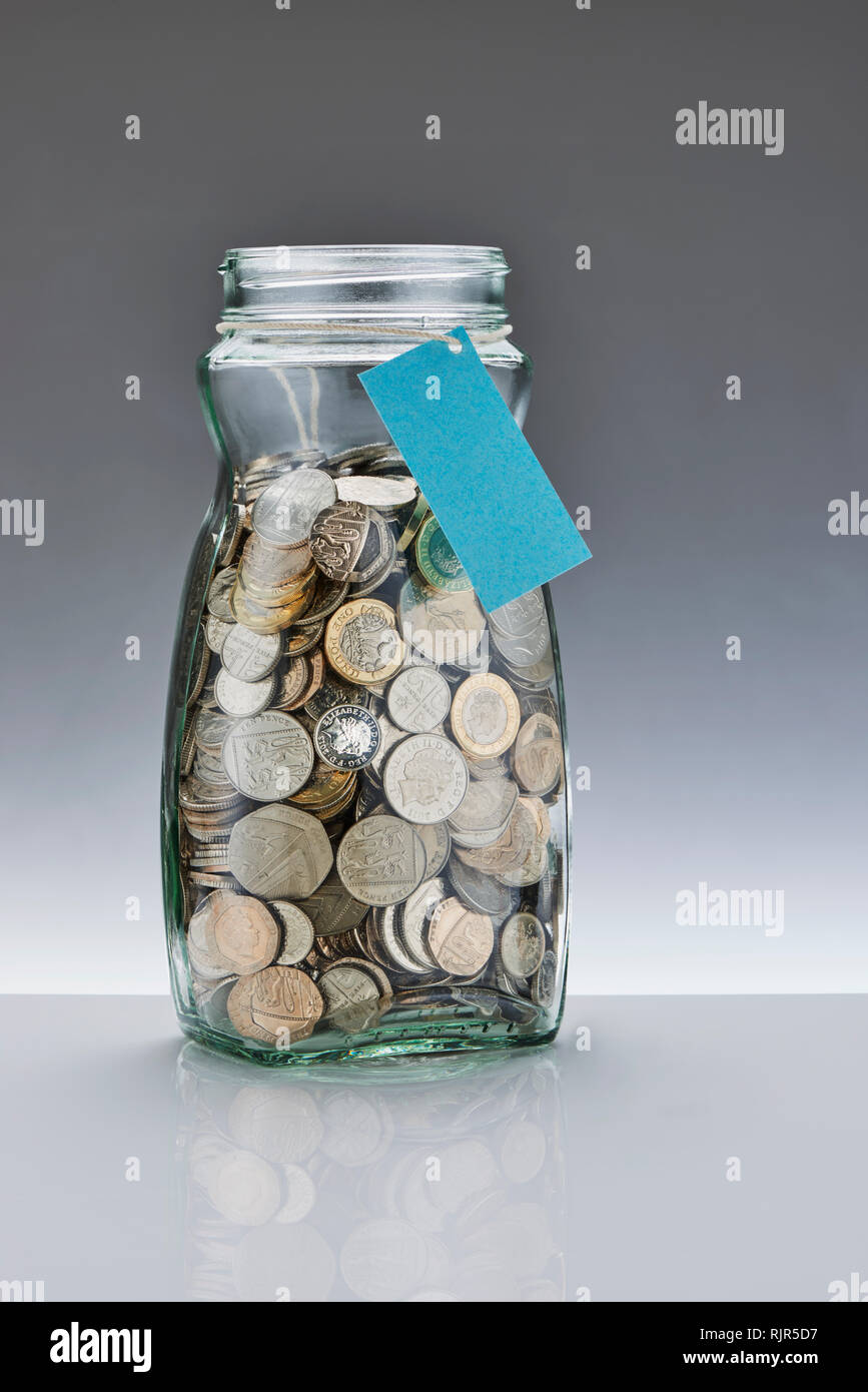 Glass Savings Jar with Pound Coins Stock Photo