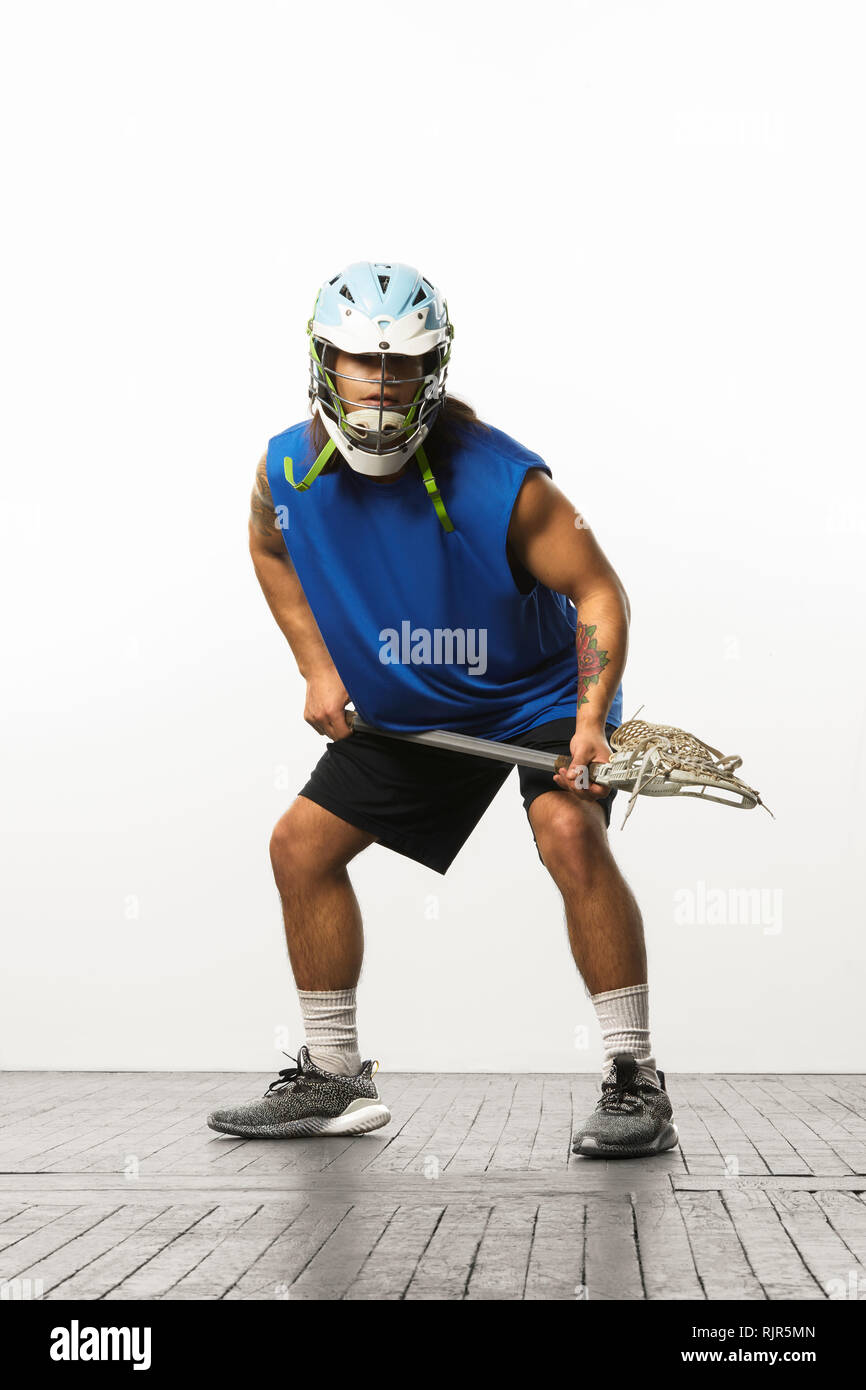 Man modelling lacrosse helmet and stick Stock Photo