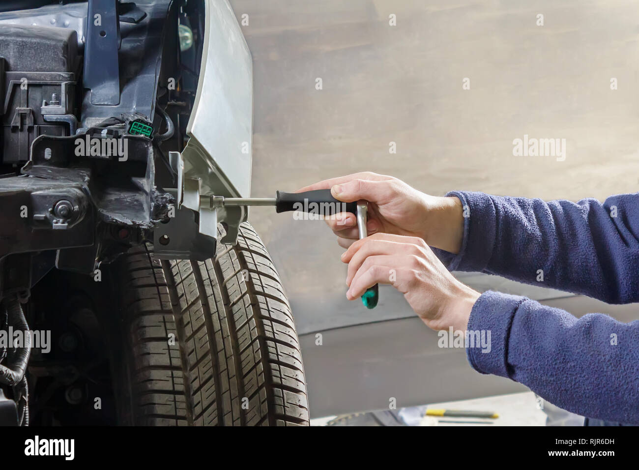 Hands of male car mechanic selecting wrench from tool box in repair garage  stock photo