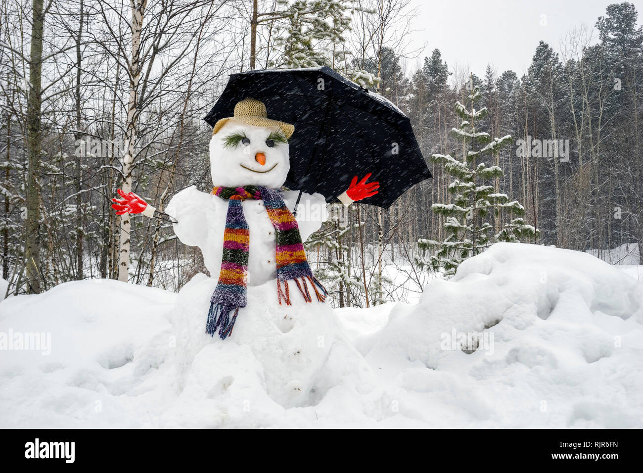 Funny snowman with an umbrella. Stock Photo