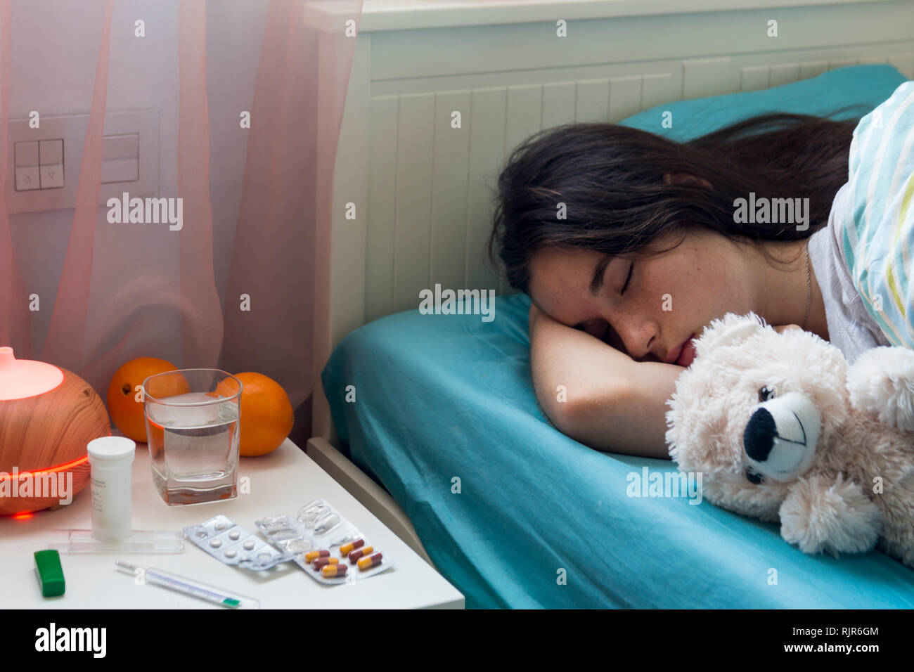 Teenage girl in bed at home caught cold, feeling bad, sleeping. Stock Photo