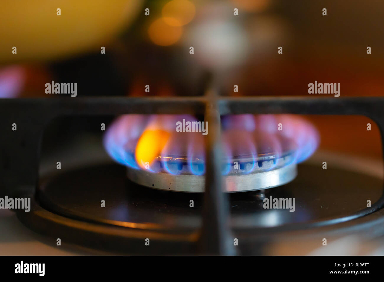Blue flame of a burning gas stove burner. Closeup, selective soft