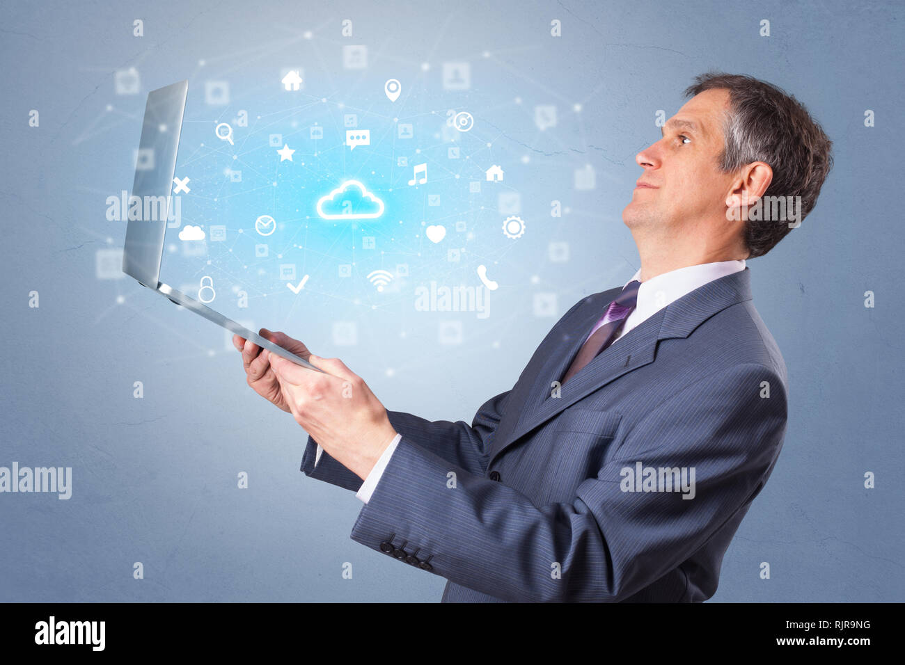 Man holding laptop projecting notifications, symbols and information based on cloud technology system  Stock Photo