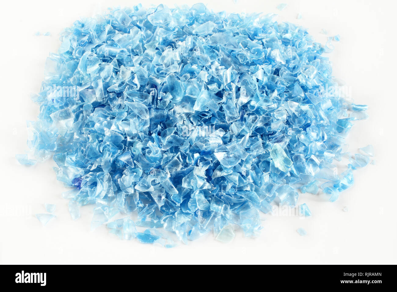 Small pieces of cut blue plastic bottles on white paper Stock Photo - Alamy