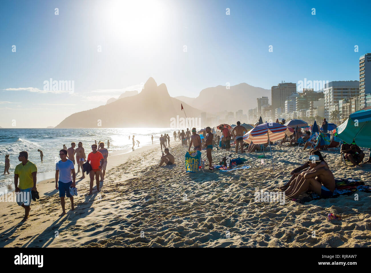 RIO DE JANEIRO - MARCH, 2017: Beachgoers stroll and socialise on a summer afternoon on Ipanema Beach. Stock Photo