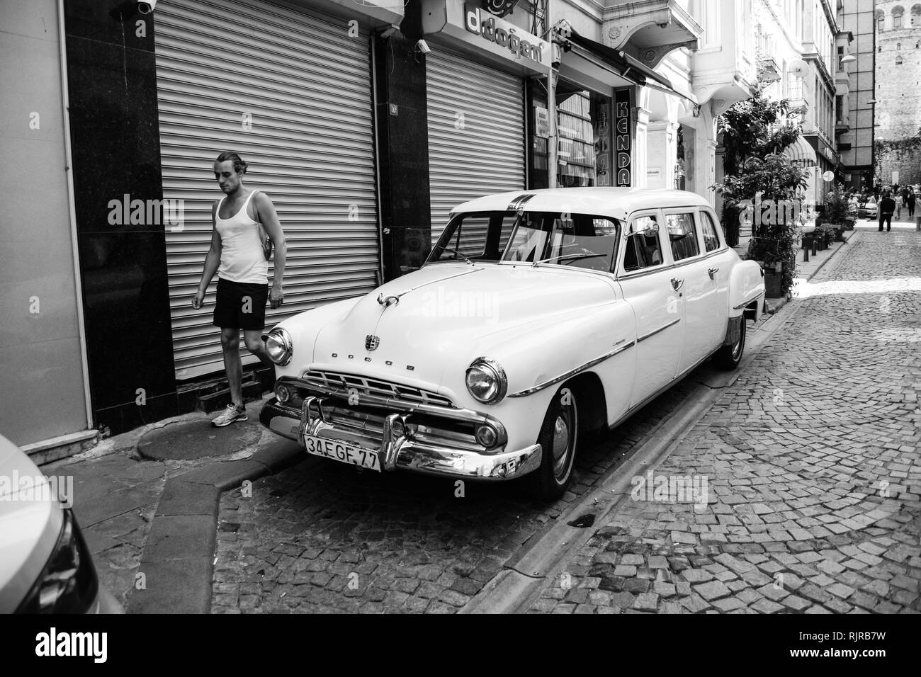 An old car and a walking man at Kuledibi district of Istanbul, Turkey. European Side. Stock Photo