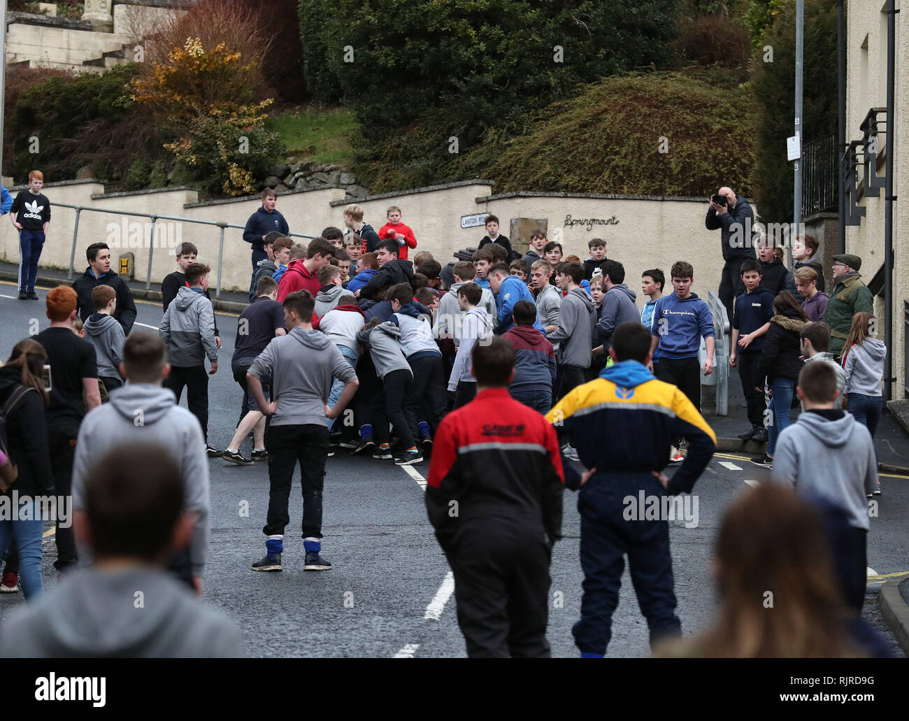 Boys tussle for the leather ball up a side street during the annual 'Fastern's E'en Hand Ba' event on Jedburgh's High Street in the Scottish Borders. Stock Photo