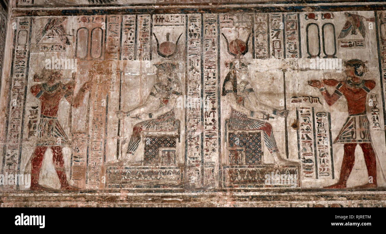 Painted wall decoration, at Temple of Hathor, Dendera, Egypt. Depicting a king making offerings to a goddess. The Hathor temple (Temple of Tentyra) has been modified on the same site starting as far back as the Middle Kingdom, and continuing right up until the time of the Roman emperor Trajan. The existing structure was built no later than the late Ptolemaic period. The temple, dedicated to Hathor, is one of the best preserved temples in all Egypt Stock Photo