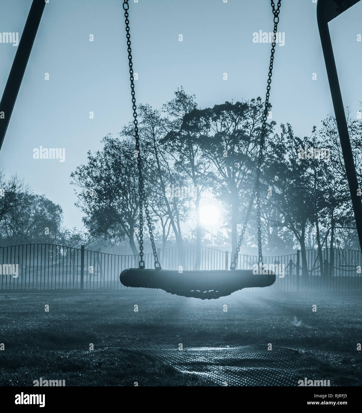 Swings in public park on a misty morning. UK Stock Photo