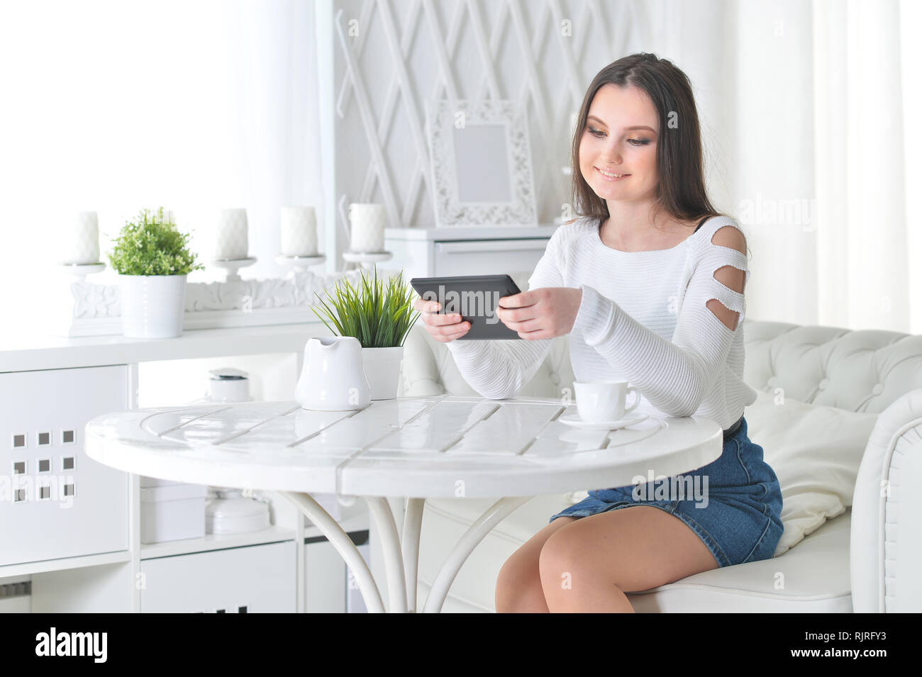 Portrait of young woman using digital tablet at home Stock Photo