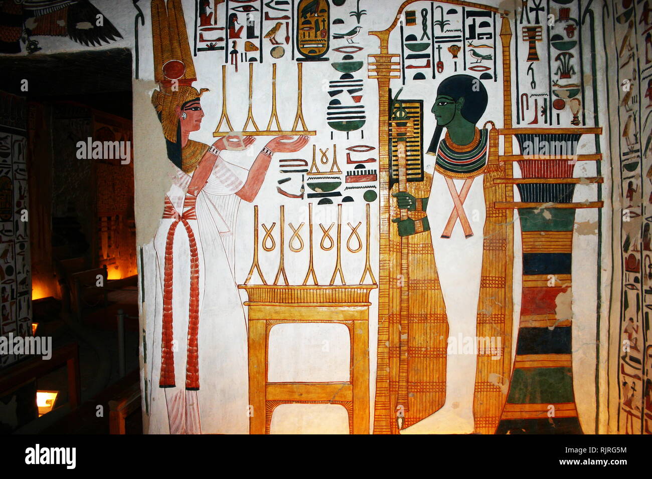 Wall Painting depicting, Nefertari and the God, Ptah. Inside the tomb (QV66) of Nefertari, Great Wife of Pharaoh Ramesses II, in Egypt's Valley of the Queens. It was discovered by Ernesto Schiaparelli in 1904. It is called the Sistine Chapel of Ancient Egypt. In the Valley of the Queens, Nefertari's tomb once held the mummified body and representative symbolisms of her, like what most Egyptian tombs consisted of. Now, everything had been looted except for two thirds of the 5,200 square feet of wall paintings. ca. 1255 BC Stock Photo