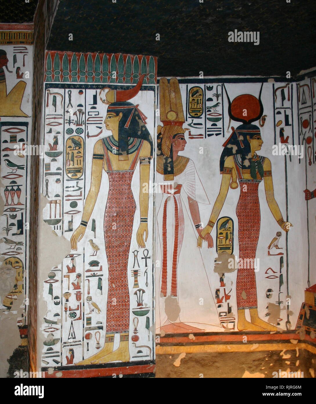 Wall Painting depicting, the Goddess Isis with Nefertari, Great Wife of Pharaoh Ramesses II, Inside the tomb (QV66) of Nefertari, in Egypt's Valley of the Queens. It was discovered by Ernesto Schiaparelli in 1904. It is called the Sistine Chapel of Ancient Egypt. In the Valley of the Queens, Nefertari's tomb once held the mummified body and representative symbolisms of her, like what most Egyptian tombs consisted of. Now, everything had been looted except for two thirds of the 5,200 square feet of wall paintings. ca. 1255 BC Stock Photo