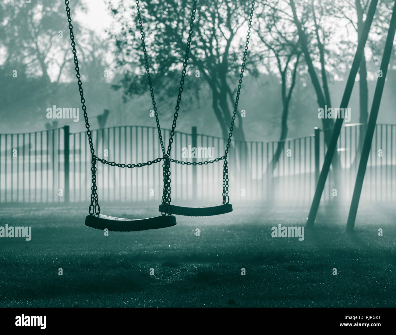 Swings in public park on a misty morning. UK Stock Photo