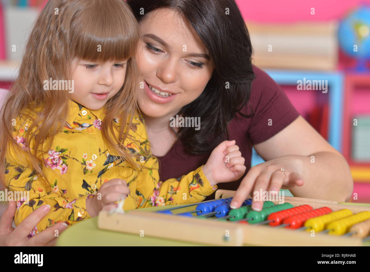 Portrait of mother teaching daughter to use abacus Stock Photo - Alamy