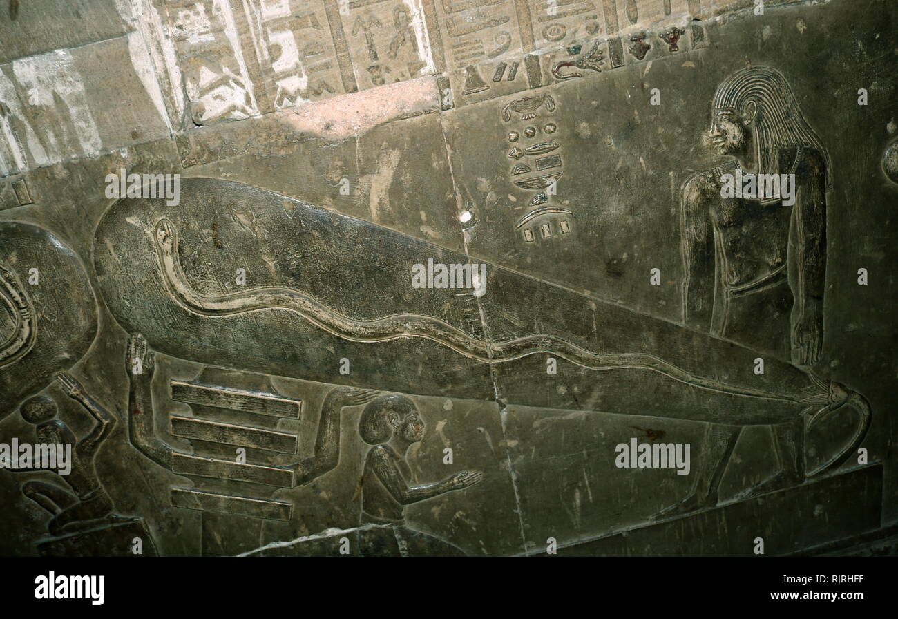 The Dendera Temple complex, which contains the Temple of Hathor, in Upper Egypt. The present building dates back to the times of the Ptolemaic dynasty. Hathor Temple has a relief sometimes known as the Dendera light because of a controversial thesis about its nature. The Dendera light images comprise stone reliefs. The view of Egyptologists is that these depict a Djed pillar and a lotus flower, spawning a snake within. In contrast to this interpretation, there is a fringe science suggestion that it is actually a representation of an Ancient Egyptian light bulb. Stock Photo