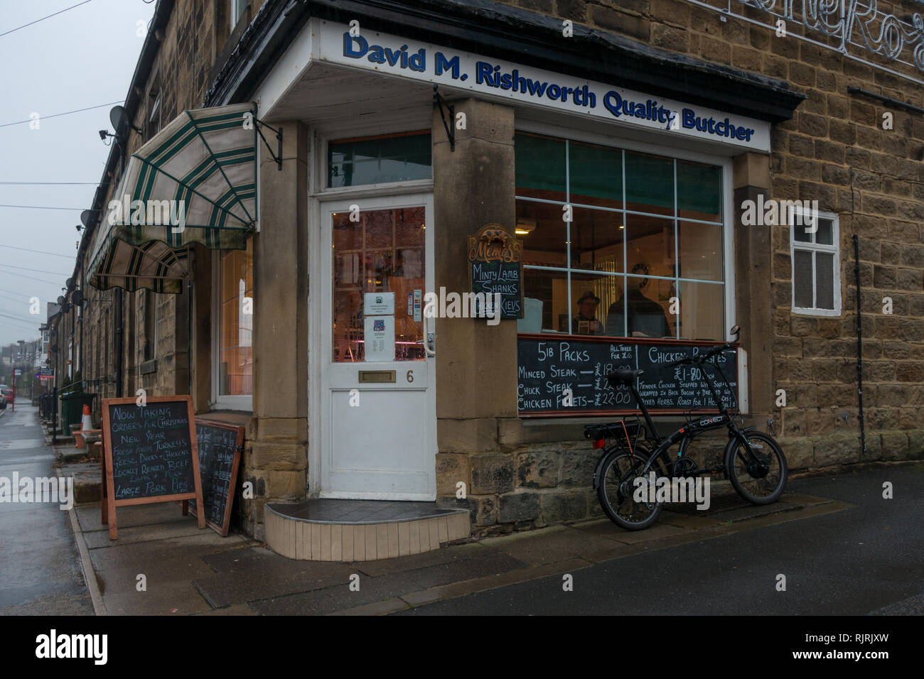 People in a traditional local butchers in Burley-in-Wharfedale village, West Yorkshire Stock Photo