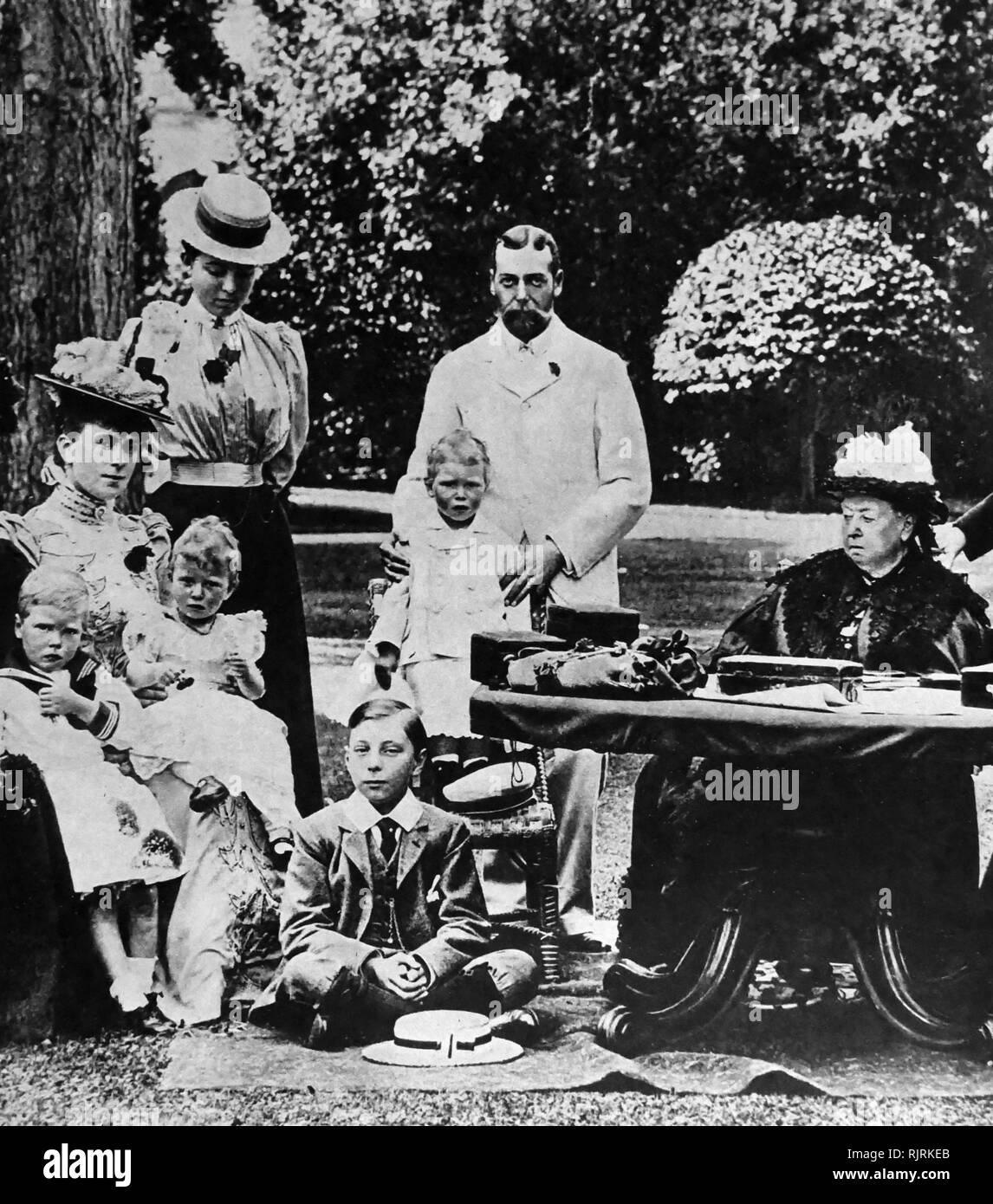 Queen Victoria of Great Britain at Osborne House with members of her immediate family; Left: Princess Mary of Teck holds Prince Edward (Edward VIII) and Princess Mary; Centre: Prince George (George V) holds the future King George VI. Stock Photo