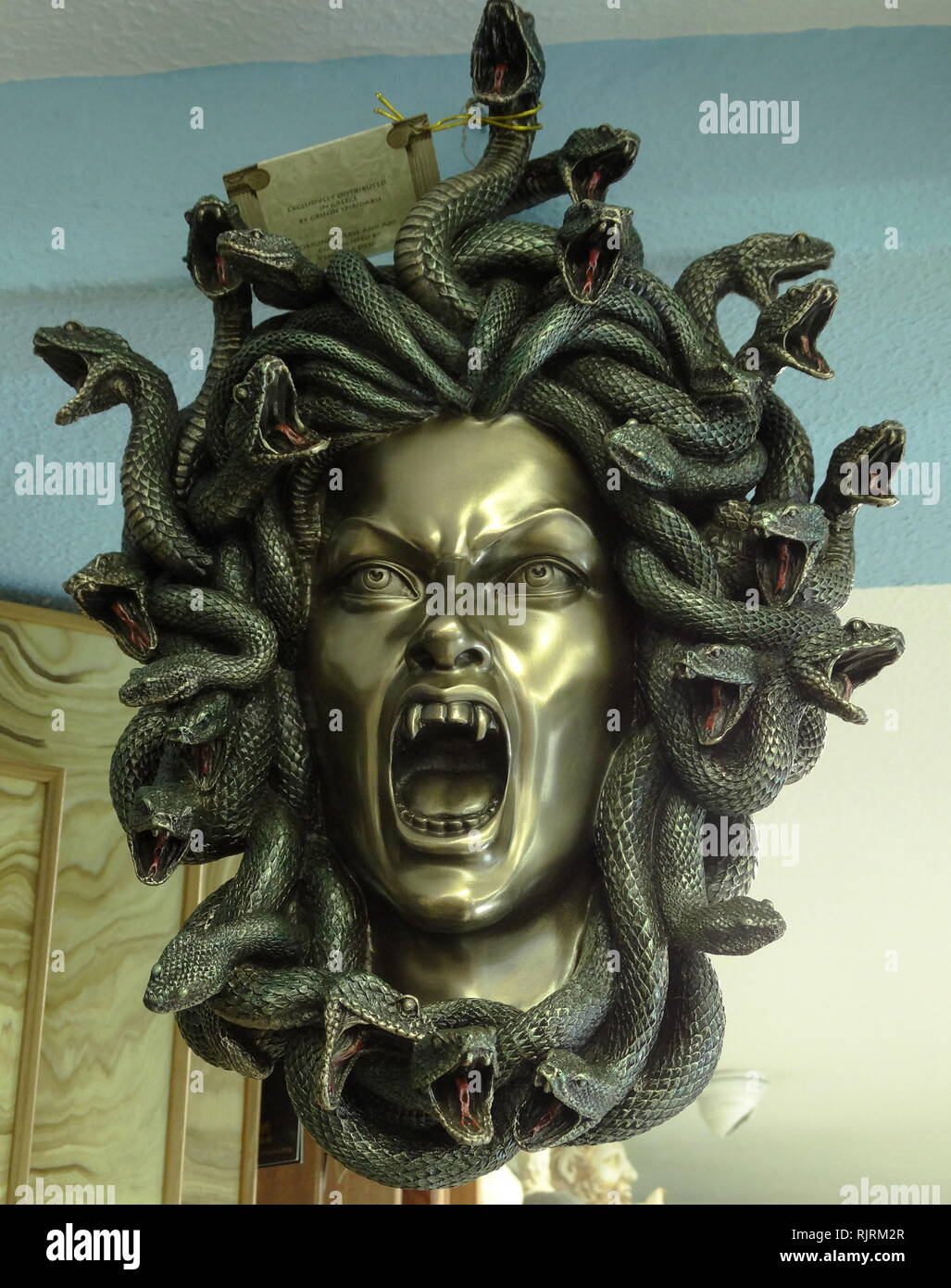 Replica head of Medusa, who was in Greek Mythology, described as a winged human female with living venomous snakes in place of hair. Gazers upon her face would turn to stone. Most sources describe her as the daughter of Phorcys and Ceto Stock Photo