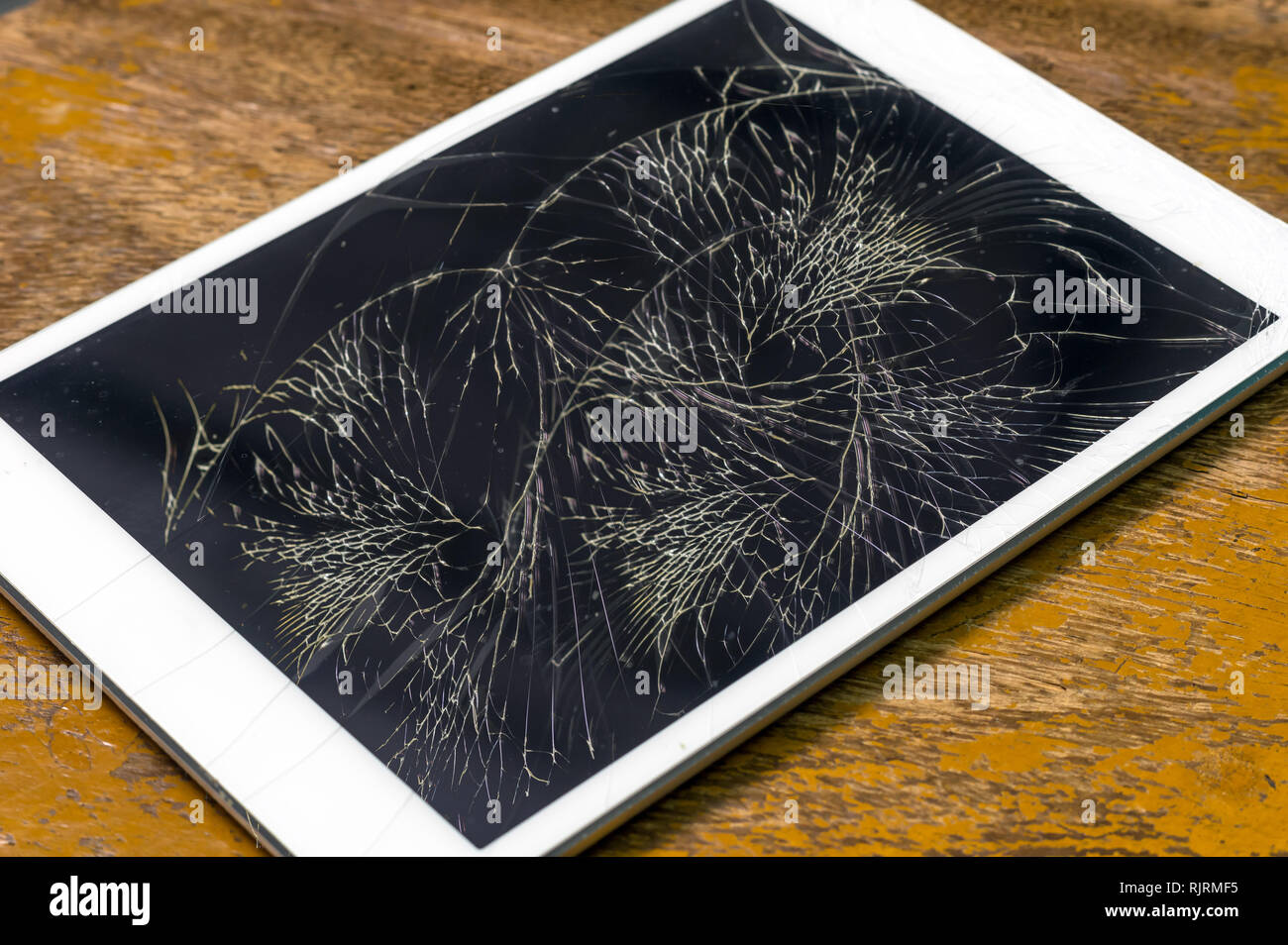 Tablet computer with broken glass screen on the wood background Stock Photo