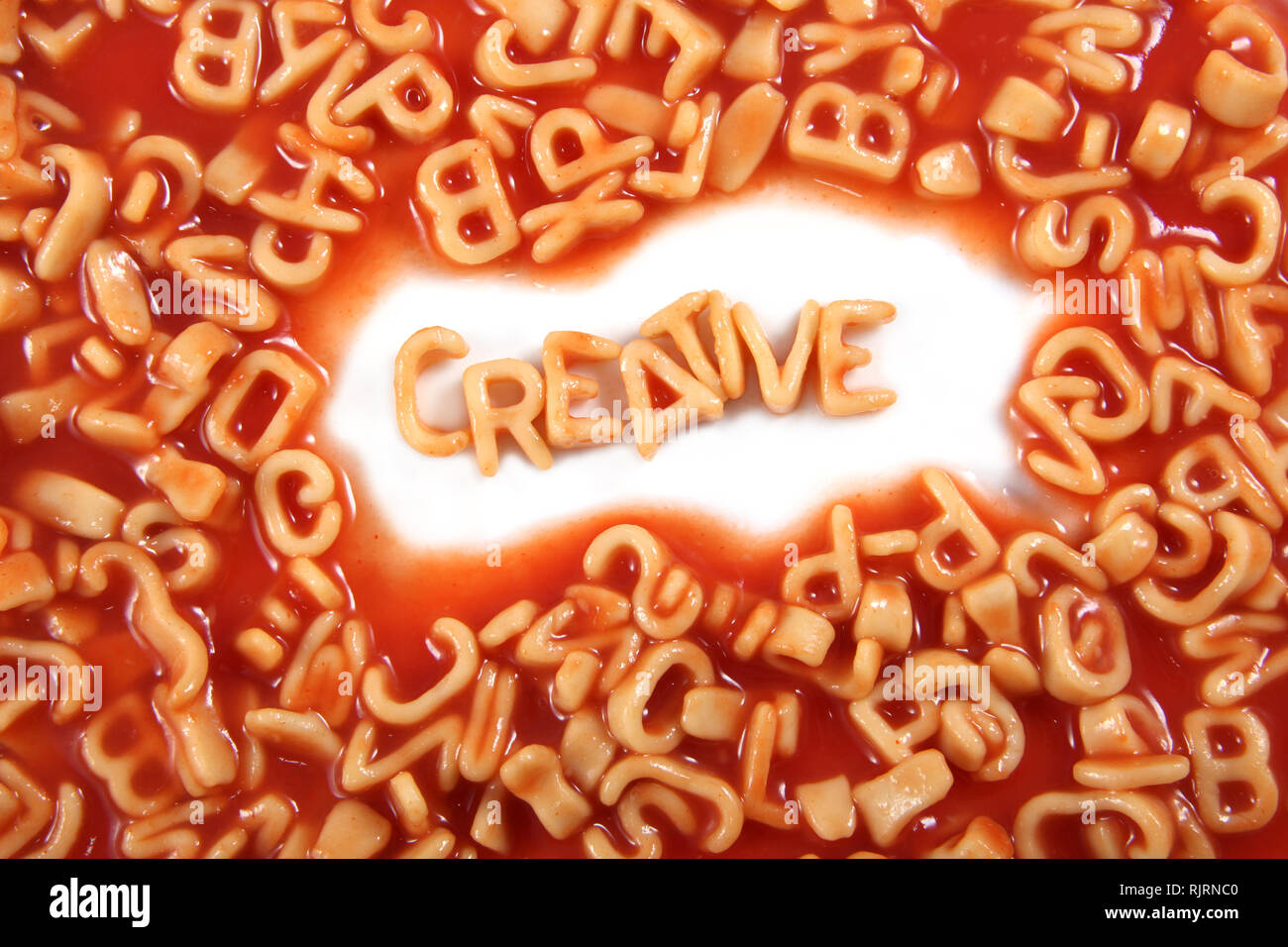 Creative written in spaghetti pasta letters surrounded with jumbled letters. Stock Photo