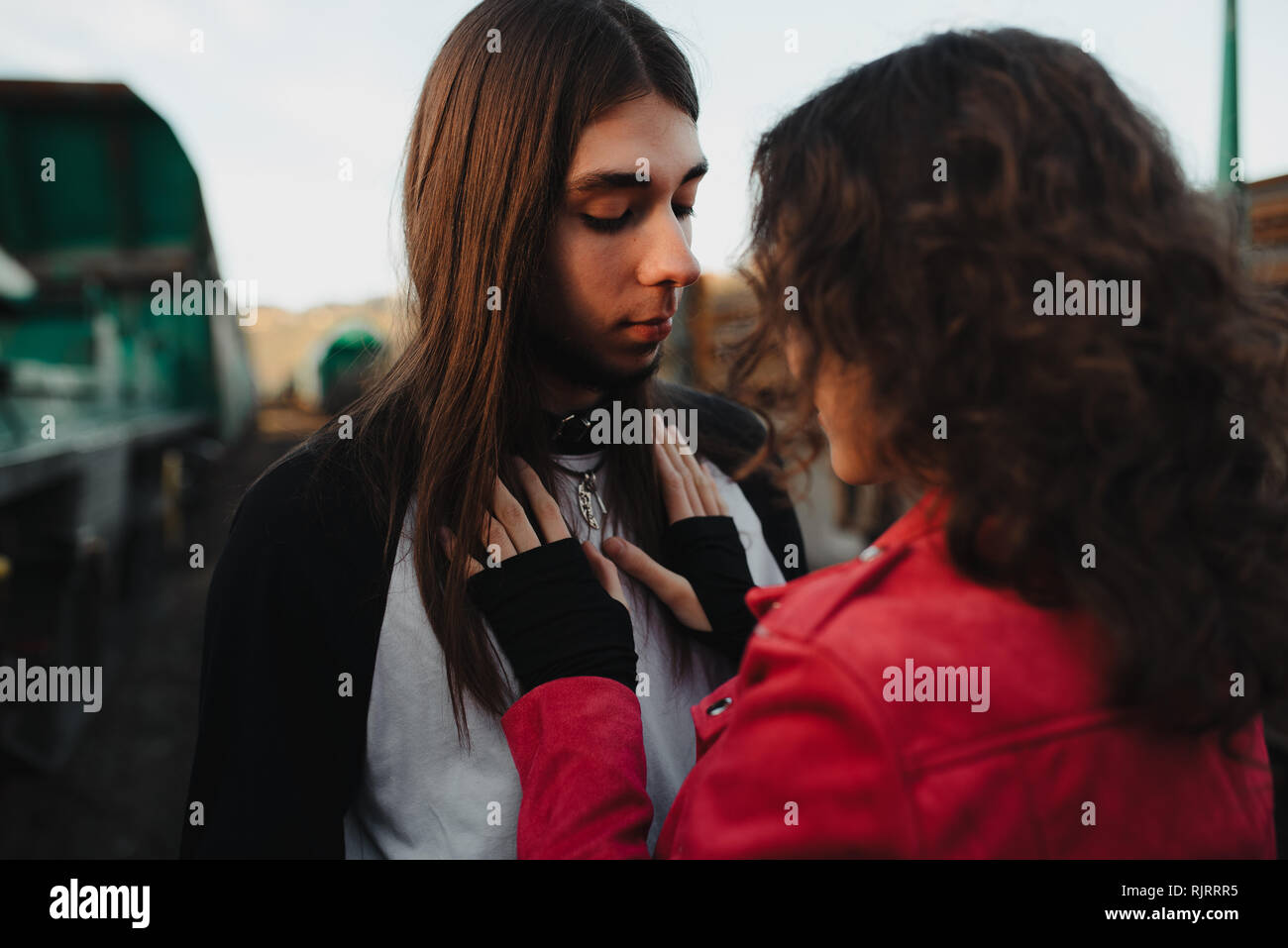 Long Haired Man Hugging And Kissing Woman Near Train Stock Photo