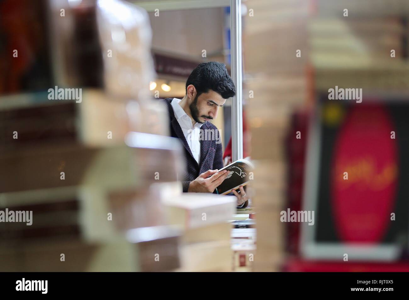 Baghdad, Iraq. 7th Feb, 2019. A man reads a book at the Baghdad International Book Fair 2019, in Baghdad, Iraq, Feb. 7, 2019. The fair kicked off Thursday with the participation of hundreds of publishers and high attendance of readers, as it sheds more light on eradicating terror and extremism in the war-torn country. Credit: Khalil Dawood/Xinhua/Alamy Live News Stock Photo