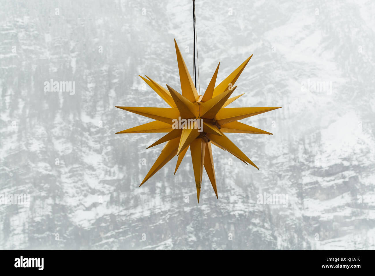 Yellow Christmas star with winter Alps mountains on the background in Hallstatt, Austria. Stock Photo