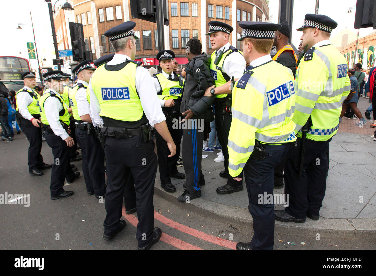 A young mans is detained by police during the annual 'Brixton Splash,' to mark Jamaican Independence Day on August 5, 2012 in London. Stock Photo