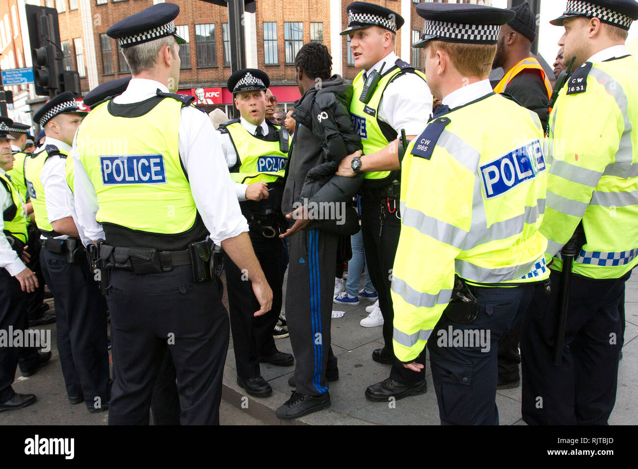 A young mans is detained by police during the annual 'Brixton Splash,' to mark Jamaican Independence Day on August 5, 2012 in London. Stock Photo
