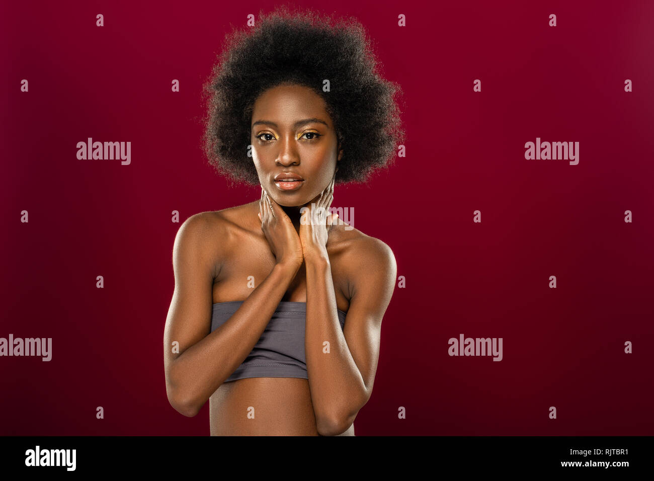 Nice pleasant young woman touching her neck Stock Photo