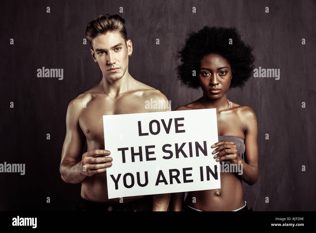 Good looking nice people standing against dark background Stock Photo