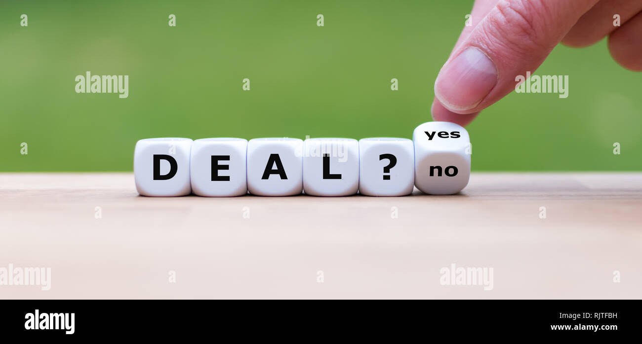 Deal or no deal? Hand turns a dice and changes the word 'no' to 'yes'. Stock Photo