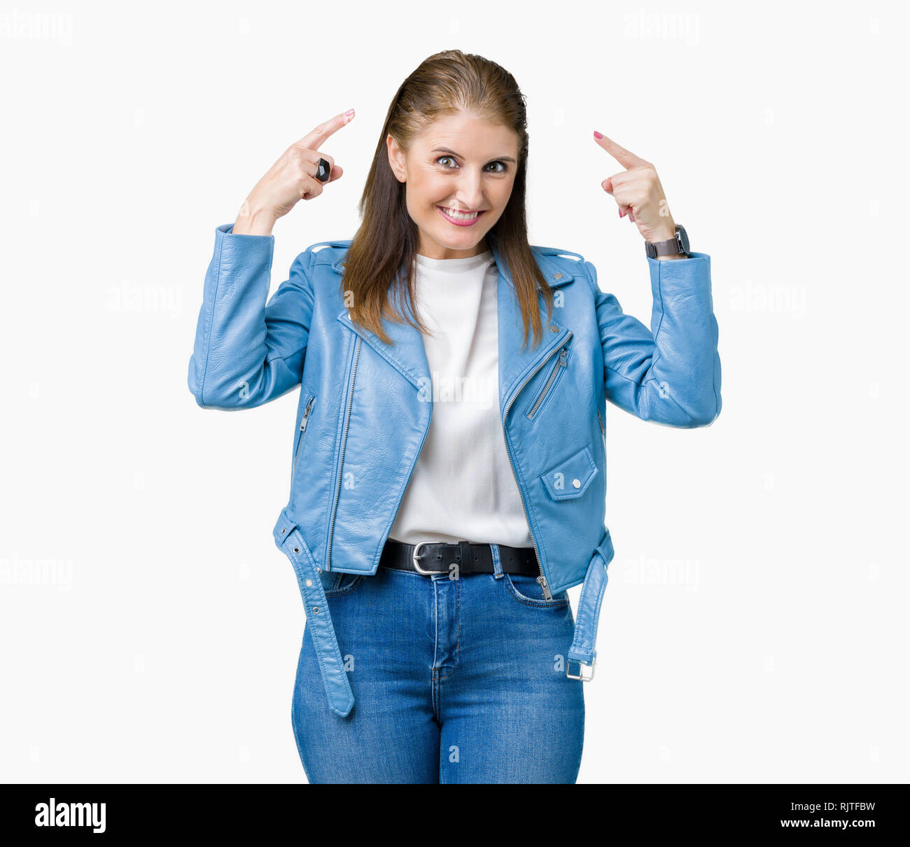Beautiful middle age mature woman wearing fashion leather jacket over isolated background Smiling pointing to head with both hands finger, great idea  Stock Photo