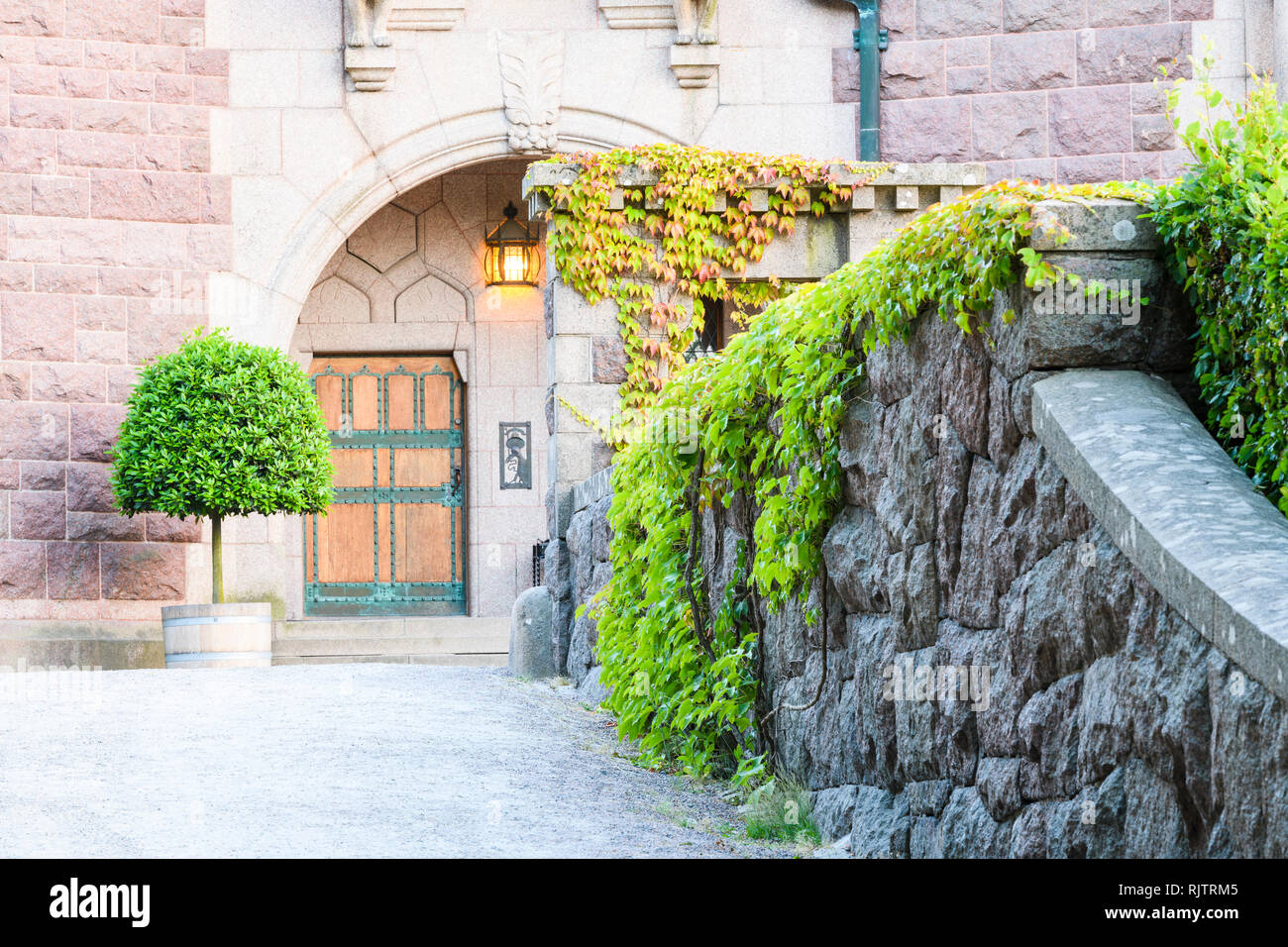 Exterior view of illuminated entrance leading to grand historic building, Halland, Sweden, Europe Stock Photo