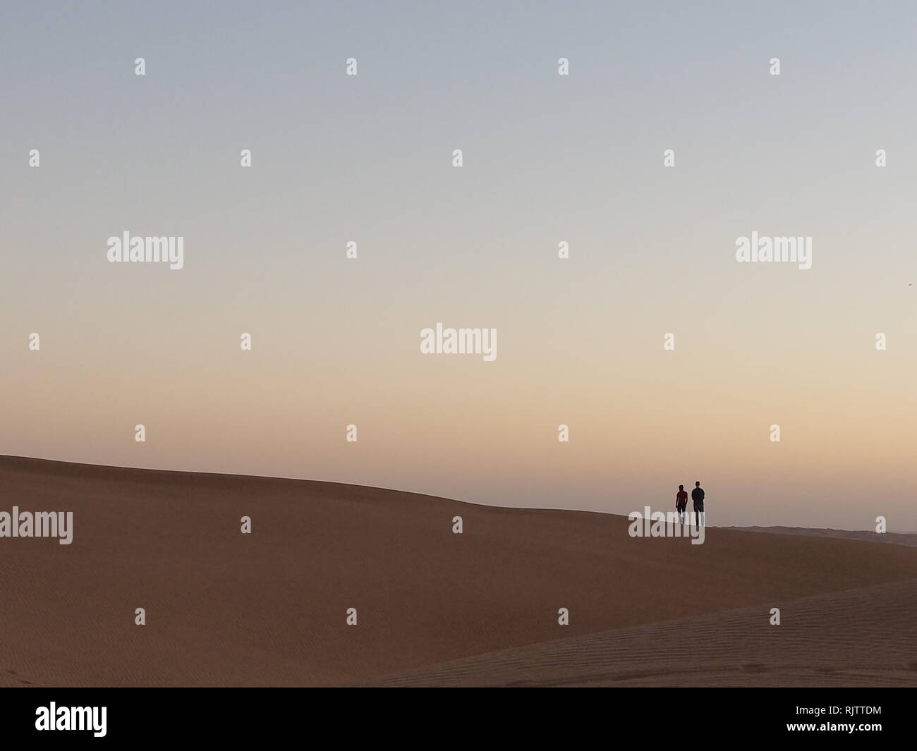 Couple of friends enjoy their visit to desert in Dubai. Stock Photo
