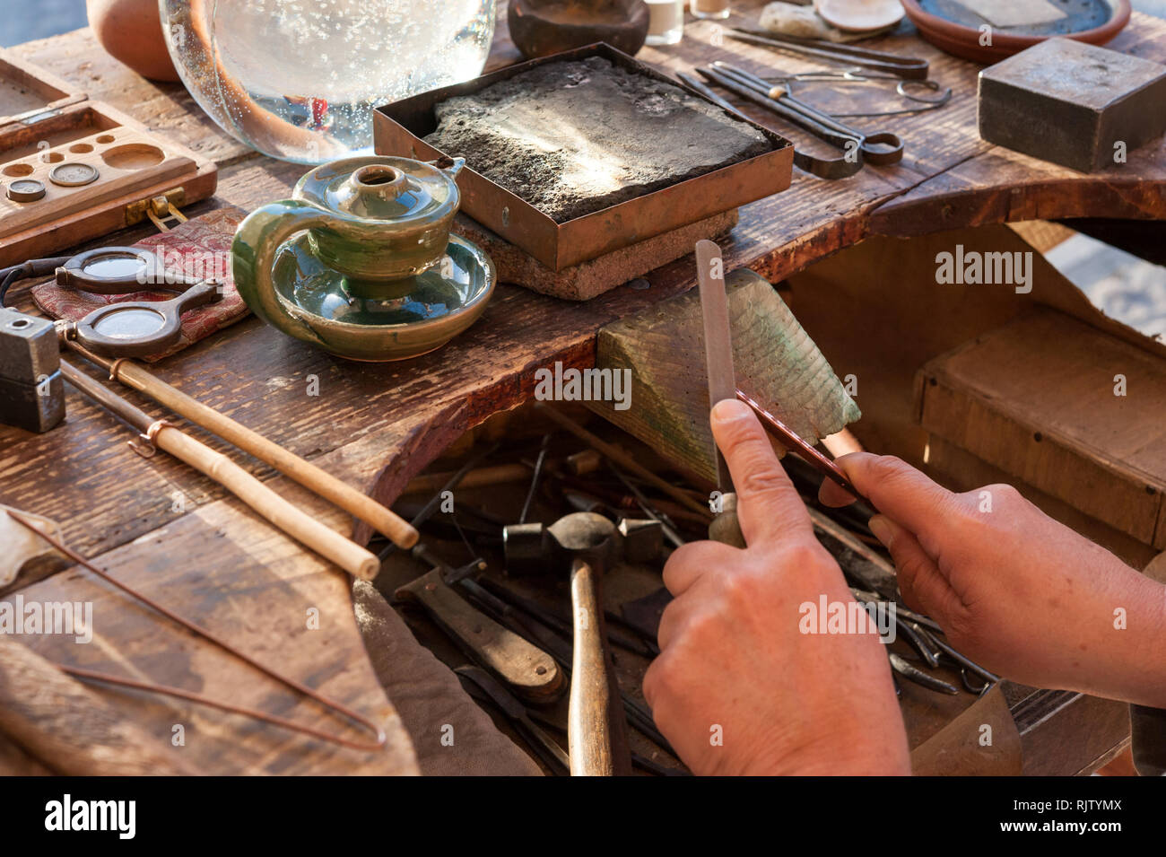 The jeweler creates a copper jewel Stock Photo