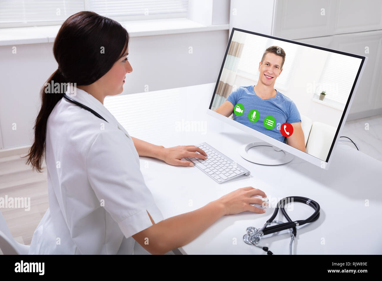 Close-up Of A Happy Doctor Video Conferencing With Male Patient On Computer  In Clinic Stock Photo - Alamy