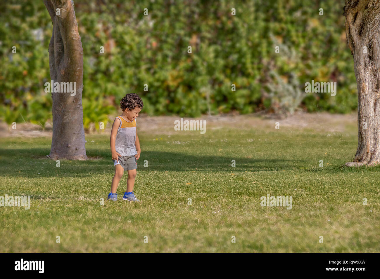 A lost little boy begins to cry and panics for his mother at the park. Stock Photo